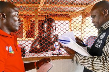 Liberia: Mr Tamba Alpha, surveillance officer, is inspecting isolation rooms at a Voinjama checkpoint with Mr Charles Ntege, WHO county coordinator. WHO/M. Winkler