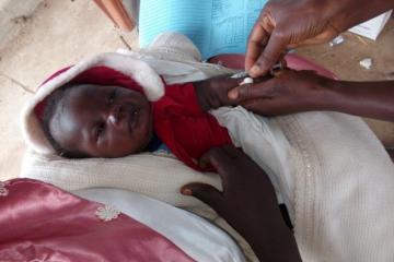 03 - A child being vaccinated against measles in Laniya