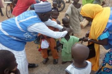 WHO personnel vaccinating a child in Gwoza