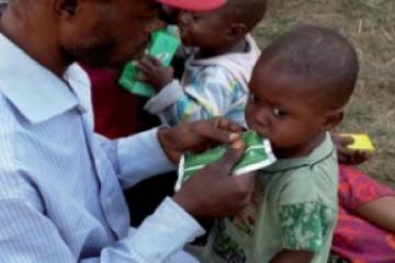 Un père de famille s’occupant à nourrir son enfant sur le site pour lui éviter la malnutrition qui guette un bon nombre d’enfants des expulsés.