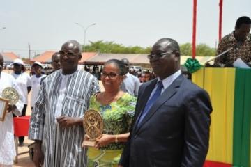 Madame le Représentant (au centre), reçoit un trophée pour la qualité de l’action et le partenariat actif de l’OMS . A sa droite, le Ministre de l’action sociale et de la solidarité nationale, Dr. Alain Zoubga et à sa gauche, le Ministre de la santé.