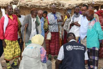 The Risk Communication Team in a discussion with a group of men in the affected community