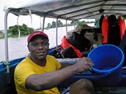 Daniel Umeh draining water from the boat after a downpour