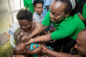 Minister of Health, Dr Diane Gashumba, administering vitamin A in the launching ceremony of MCH Week