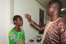 A young girl assisted in measuring her BMI