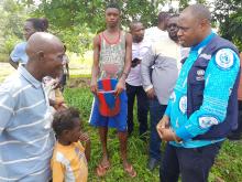 Un ancien malade (à gauche), aujourd'hui totalement guéri de la THA, livrant son témoignage à un expert de l'OMS au village Jeune Foire, dans l'aire de santé de Lutendele, au sud-ouest de Kinshasa. Il a amené également sa famille (son épouse et ses deux enfants) auprès de l'unité mobile pour le dépistage de la maladie du sommeil. OMS/Eugene Kabambi