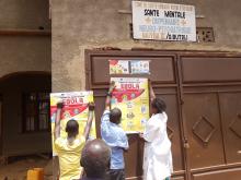 People from Butsili area, in Beni (North Kivu) are reading EVD key messages on the poster to raise awareness of their community. WHO/Eugene Kabambi