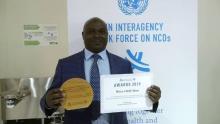 Honorable Minister of Health Jappie Mhango MP holding the UN Interagency Task Force award for NCD prevention and control