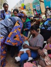 WHO FCT State Coordinator administering oral polio vaccine to an eligible child