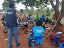 A WHO officer conducting COVID-19 community engagement in a refugee community