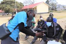 Tracy Chigumba showing Mr. Tonde Sigauke how to enter data 