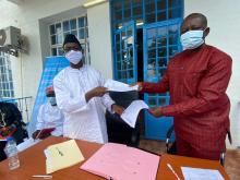 L-R: the Minister of Health and Sanitation receiving the certificate of donation from Mr Evans Liyosi, WHO Representative in Sierra Leone