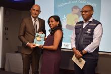 An expectant mother receiving a copy of the MCH Handbook from Dr Hon k. K. Jagutpal, Minister of Health and Wellness in the presence of Dr L Musango, WHO Representative in Mauritius