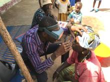 A woman being thoroughly screened by an optomologist