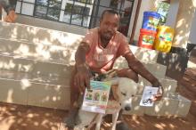 A dog owner holding awareness materials disseminated during the vaccination campaign