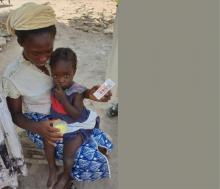 A caregiver administering the SMC drug to her eligible child. Photo_credit_ Nglass_WHO