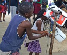 Children using a tippy tap constructed with support from Community Health Workers  at their house as part of promoting hand hygiene to control the HEP E outbreak in Outapi, Omusati Region in 2021