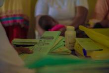 A nurse cross-checking vaccination cards of children presented for vaccination