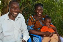 Moses and his wife Christina holding their one-year-old baby delivered after an emergency ambulance transported Christina to Kidera Health Centre IV in Buyende district