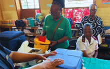 Dr Simangele Mthethwa, WHO South Africa NPO (VPD Surveillance) captured during the 2023 measles vaccination campaign, symbolizing determination and responsibility as she inspects vaccines at a vaccination center. Her earnest expression reflects a commitment to eliminating measles in South Africa.