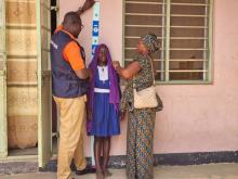 Healthcare professionals utilize a "dose pole" to measure the height of students, determining the appropriate dosage of medicine during the MDA