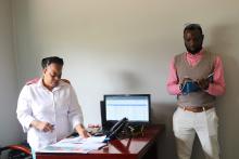 Dr Arisekola Jinadu taking notes during the team’s visit to the Public Health Emergency Operation Centre while Sister Rosemary Ngwenya explains how the centre operates