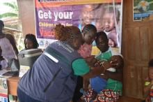 Shedrick Barlee, with his one-year-old son Blessed Barlee, at the vaccination campaign