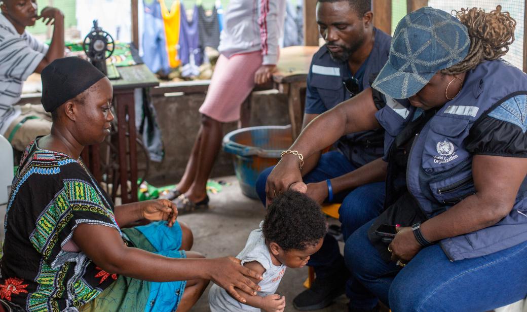 WHO staff in the field examining a suspected Acute Flaccid Paralysis (AFP) case in a child- a key component of a polio vaccination campaign  