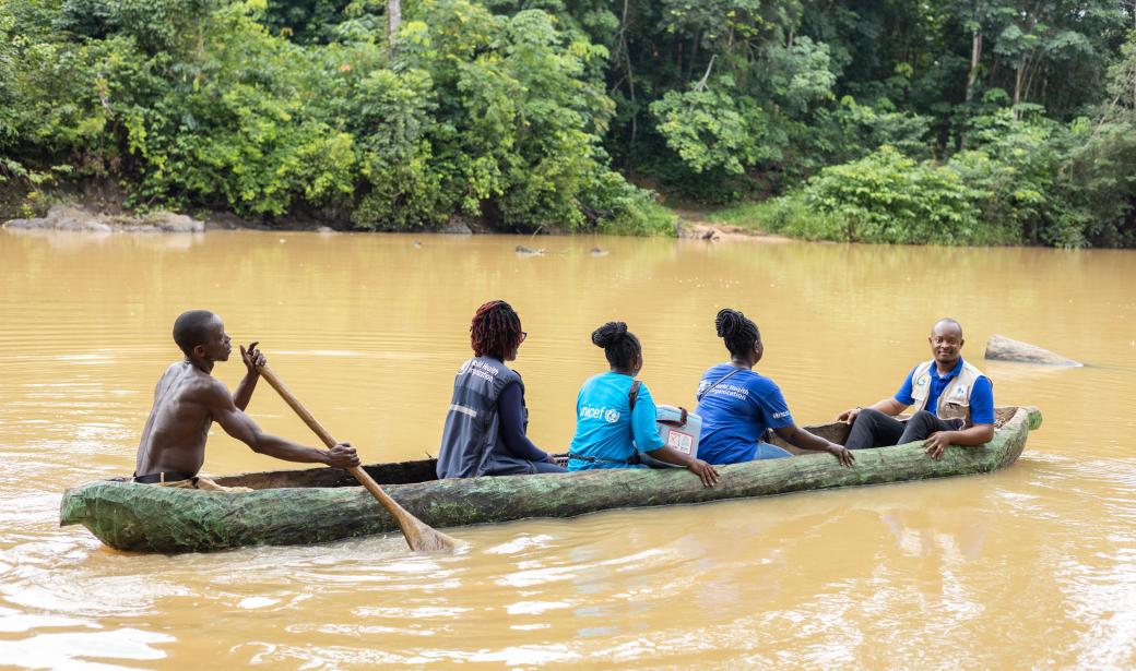 A team of front liners in a canoe crossing the river to ferry vaccines to eligible children in the county