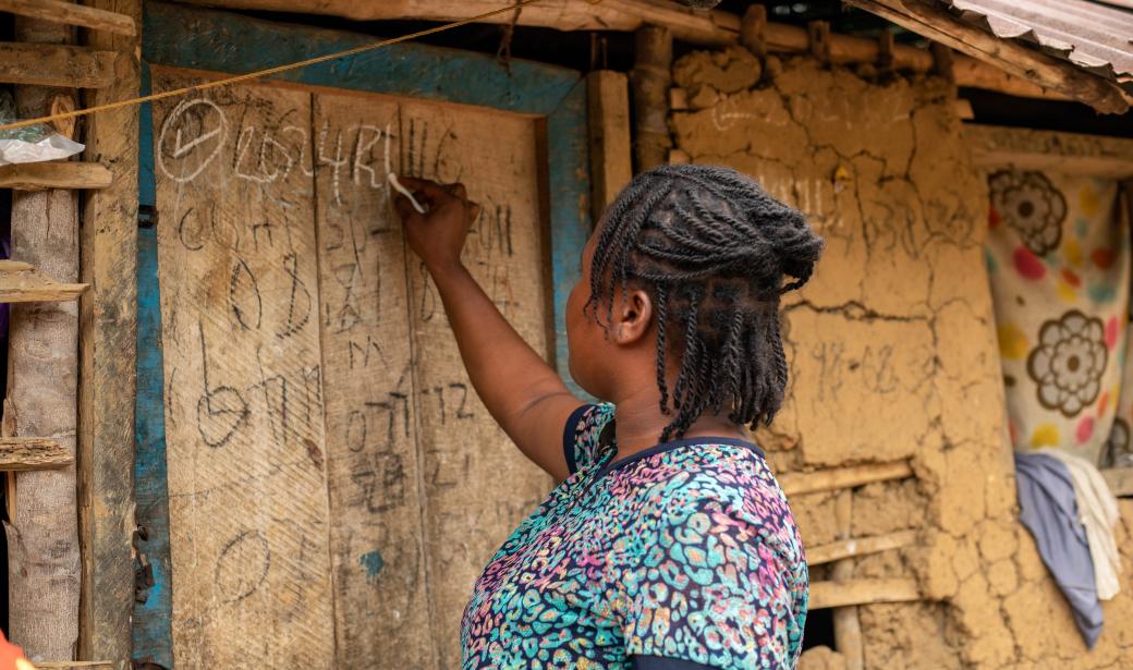 Massa J. Hokokoh a vaccinator in Monagi town, Carryesburg district marking the door of the house after administering the polio vaccine.